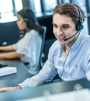 Zwei Mitarbeitende mit Headset beraten Kund:innen am Telefon