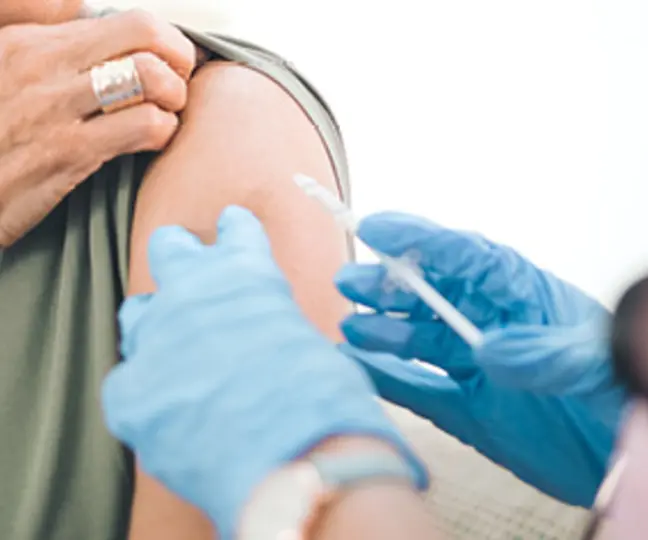 Un médecin vaccine une patiente