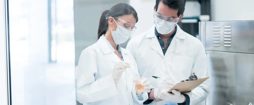 Zwei Chemiker, die im Labor Produkte in Reagenzgläsern mischen
