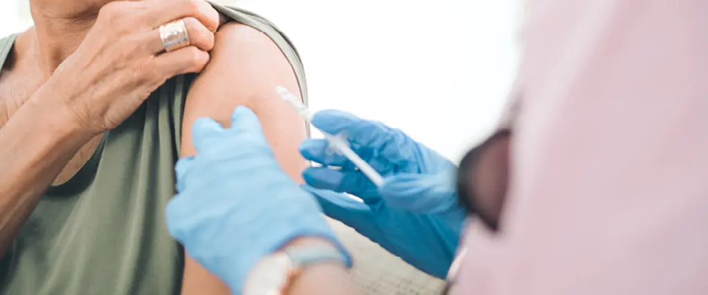 Un médecin vaccine une patiente