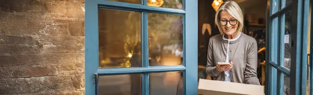Frau mit Paket in der Tür