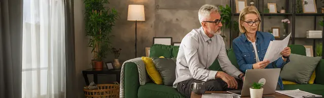 Paar auf Couch mit mehreren Unterlagen
