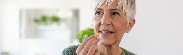 Frau die eine Pille einnimmt 