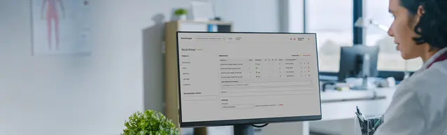 Ärztin sitzt vor einem Monitor auf dem der neue Zur Rose Rezeptmanager zu sehen ist.