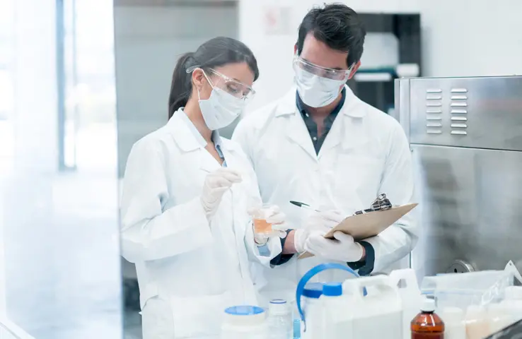 Zwei Chemiker, die im Labor Produkte in Reagenzgläsern mischen