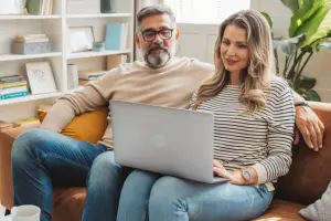 Paar mit Laptop auf Couch