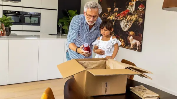 Grossvater mit Enkelin packt Paket aus
